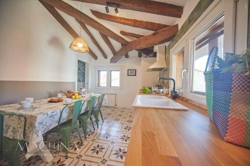 a kitchen with a table with chairs and a sink at El Capricho de Comillas in Comillas