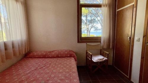 een kleine kamer met een bed en een raam bij Casa Gloria Begur in Begur
