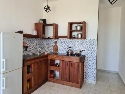 una cocina con fregadero y refrigerador en Five Seasons Zanzibar opposite Mnemba island Hotel, en Makunge