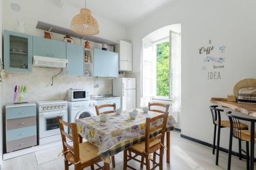 a kitchen with a table and a kitchen with blue cabinets at 2 appartamenti totale 12 posti letto in Borgonovo