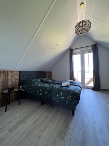 een slaapkamer met een bed en een groot raam bij FeelzFree by Reggehoeve in Hellendoorn