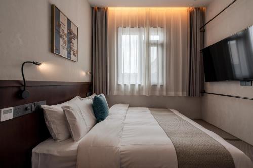 a hotel room with a bed and a television at Jingmao Alley Hotel - Beijing Wangfujing Dongsi Subway Station Branch in Beijing