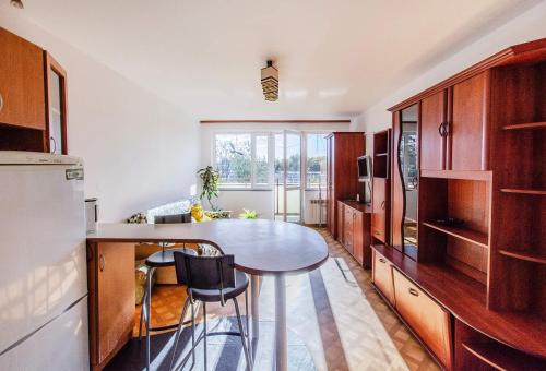 a kitchen with a table and a kitchen with a refrigerator at Fat Kaz Apartment in Wrocław