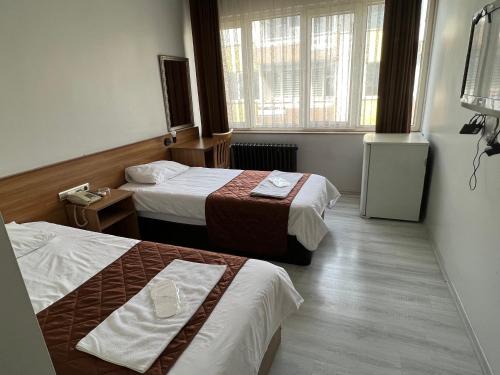a hotel room with two beds and a window at Altinnal Hotel in Kocaeli