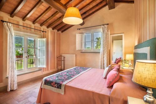 una camera con un grande letto e due finestre di Le Vigne a Capannori