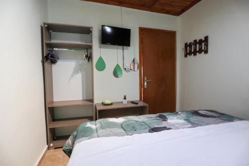 a bedroom with a bed and a tv on the wall at Κυανή Ακτή - Agia Paraskevi in Mákri