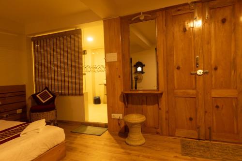 a bedroom with a bed and a wooden door at Subha Casa Hotel in Pātan