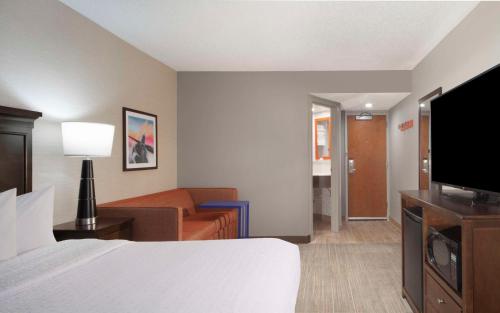 a hotel room with a bed and a television at Hampton Inn Evansville in Evansville