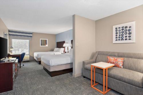 a hotel room with a bed and a couch at Hampton Inn Rock Hill in Rock Hill