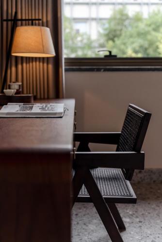 a desk with a lamp and a chair next to a window at Jingmao Alley Hotel - Beijing Wangfujing Dongsi Subway Station Branch in Beijing