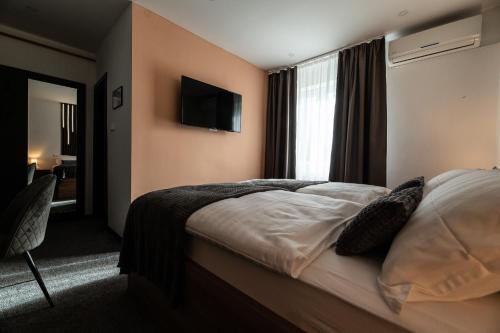 a hotel room with a bed and a television at Soba za noćenje Tončica in Požega