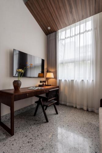 an office with a desk with a vase on it at Jingmao Alley Hotel - Beijing Wangfujing Dongsi Subway Station Branch in Beijing