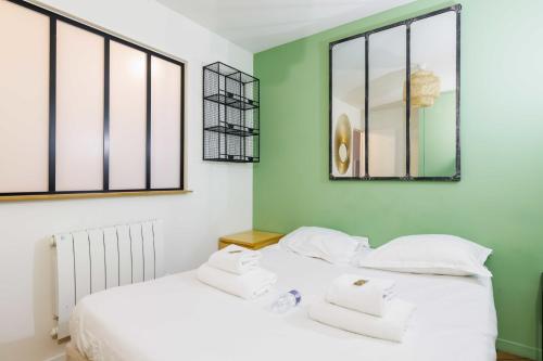 2 camas en una habitación con paredes y ventanas verdes en Chic Parisian Retreat - Porte de Montreuil - 2, en París
