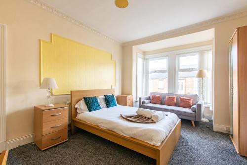 um quarto com uma cama e um sofá em Imeary - 3BR Terraced Near S. Shields em South Shields