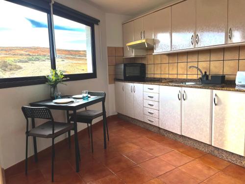 a kitchen with a table and chairs and a window at Apartamento Guanapay by Vulcano Homes in Teguise