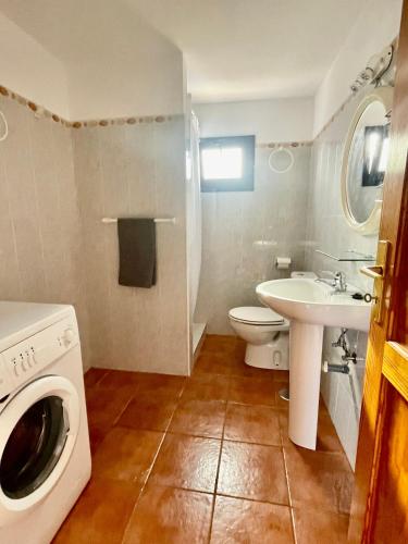 a bathroom with a washing machine and a sink at Apartamento Guanapay by Vulcano Homes in Teguise