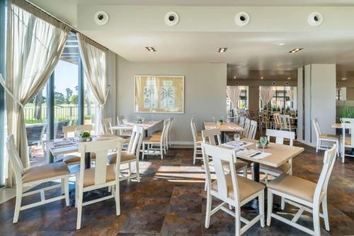a restaurant with tables and chairs and windows at Barceló Costa Ballena Golf & Spa in Costa Ballena