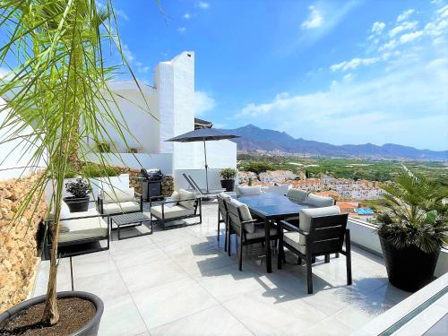 a patio with a table and chairs on a balcony at Fantastic view near the beach in Nerja in Nerja