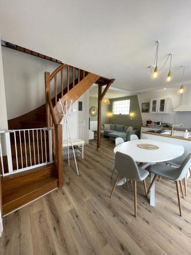 une salle à manger et un salon avec une table et des chaises blanches dans l'établissement Gîte D'à Côté, 5 mn du Zoo de Beauval, à Seigy