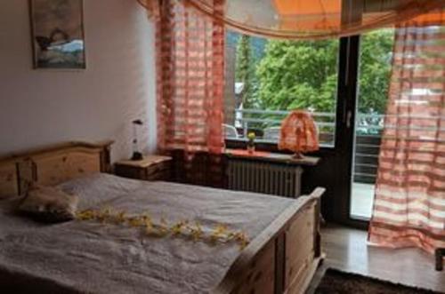 a bedroom with a bed and a large window at Ferienwohnung am Weissensee mit Pool,Sauna in Füssen