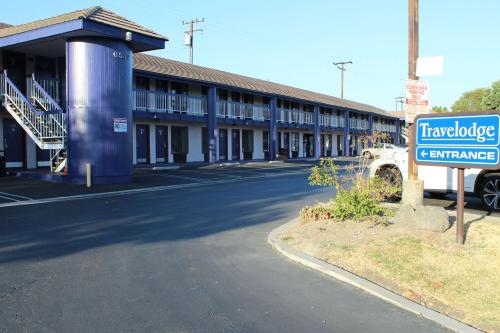 a building with a sign in front of it at Travelodge by Wyndham Buena Park in Buena Park