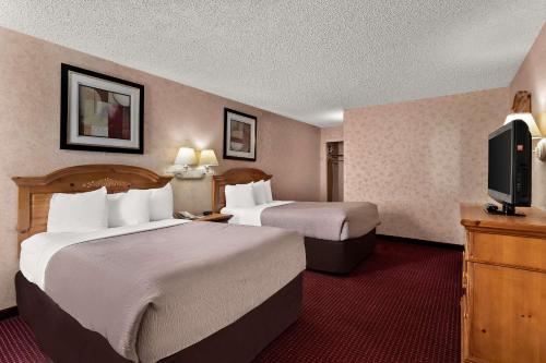 a hotel room with two beds and a flat screen tv at Quality Inn & Suites in Craig