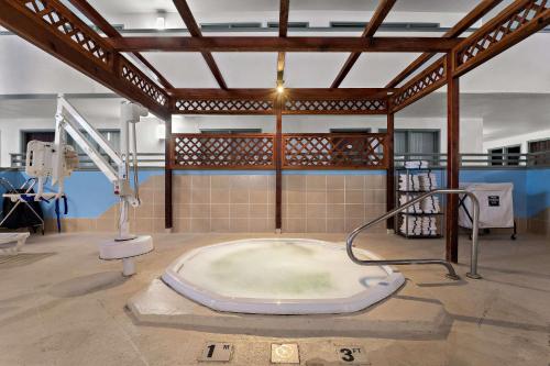 Quality Inn & Suites في كريج: حمام كبير مع حوض استحمام في الغرفة