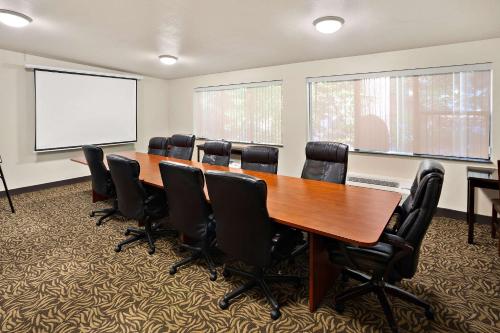 a conference room with a long wooden table and black chairs at Comfort Inn Lacey - Olympia in Lacey