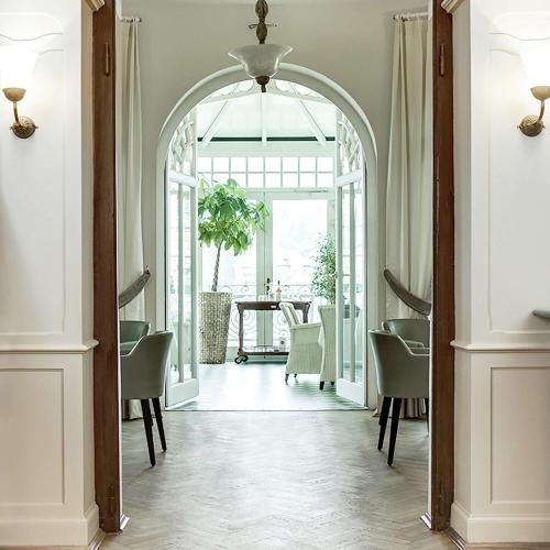 an archway leading into a dining room with a table at Dorint Parkhotel Meißen in Meißen