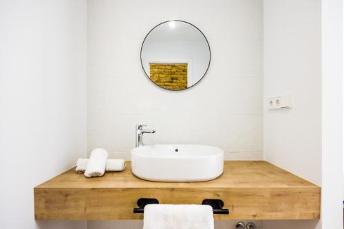 une salle de bain avec un lavabo et un miroir dans l'établissement Apartamentos Turísticos Decumano Romano by CartagenaSpain, à Carthagène