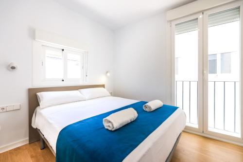 1 dormitorio con 1 cama grande y 2 toallas. en Apartamentos turísticos Decumano Romano, en Cartagena