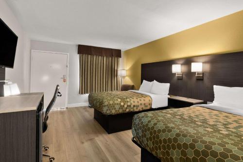 a hotel room with two beds and a television at Econo Lodge White Pine Morristown I-81 & I-40 Split in White Pine