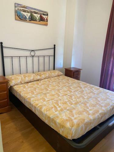 a bedroom with a large bed with a yellow comforter at Casa con piscina in Madrid