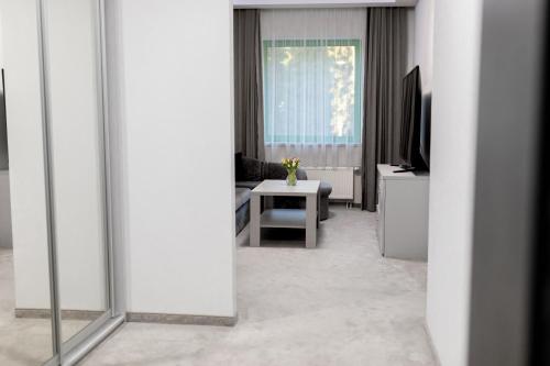 a living room with a table and a television at Hotel Promenada Biznes & Wypoczynek in Radom