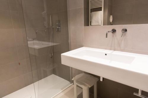 a white bathroom with a sink and a shower at Art Hotel Museo in Prato