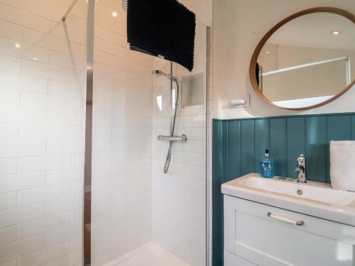 a bathroom with a shower and a sink and a mirror at 3 Albion Cottages in Southwold