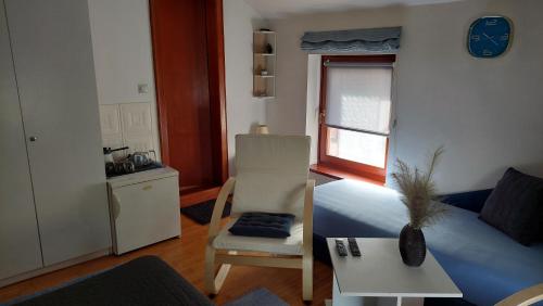 a room with a bed and a chair and a window at Apartments Bikica in Vrnjačka Banja