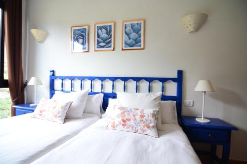 1 dormitorio con 2 camas con sábanas y almohadas blancas en Apartamentos Los Telares en Hermigua