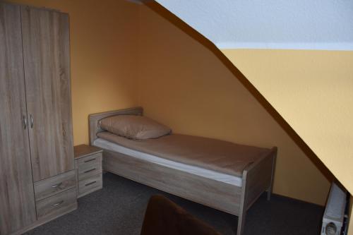 a small bedroom with a bed and a closet at Hotel La-Pergola in Kolkwitz