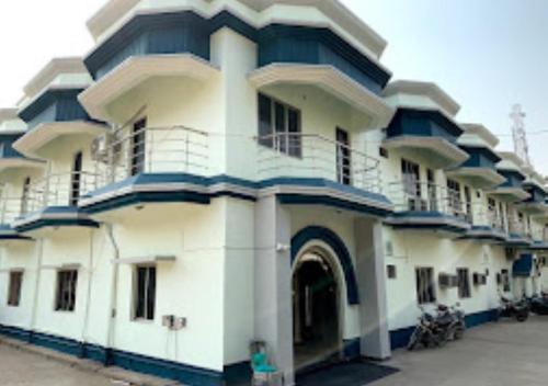 Un grand bâtiment blanc avec un balcon est à votre disposition. dans l'établissement Hotel R.K.Palace Jharkhand, à Pākaur