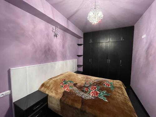 a bedroom with a large bed and a chandelier at Daily Rental Apartment 12 in Tsaghkadzor