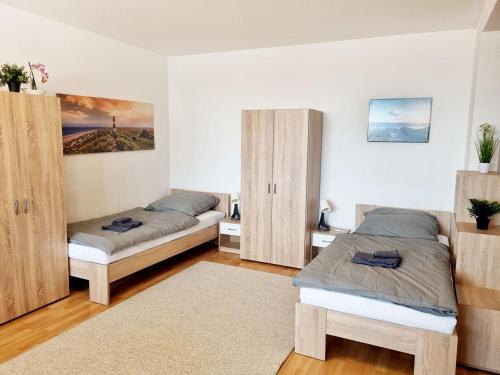 Main Apartments in Hattersheim في هاترزهايم: سريرين في غرفة مع دواليب خشبية