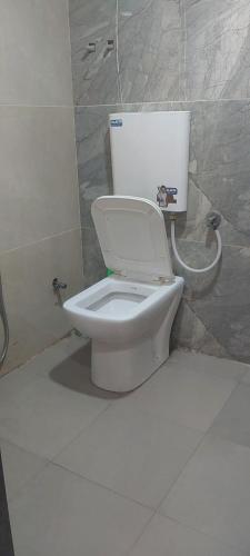 a bathroom with a white toilet in a room at Anant home stay in Ujjain