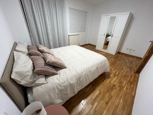 Un dormitorio con una cama con almohadas y un espejo. en 20 Pasos, en Tudela