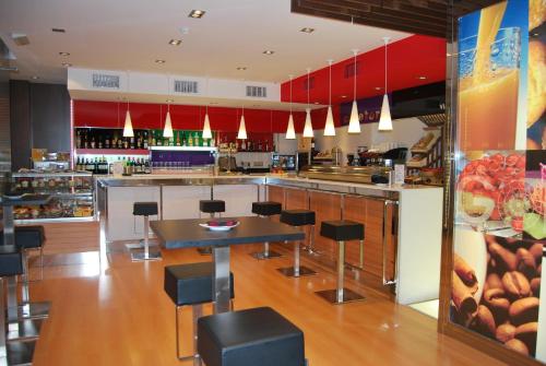 a fast food restaurant with a counter and chairs at Hotel Vía Gótica in Burgos