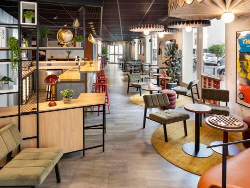 un restaurante con mesas y sillas y un bar en ibis Paris Nation Davout en París