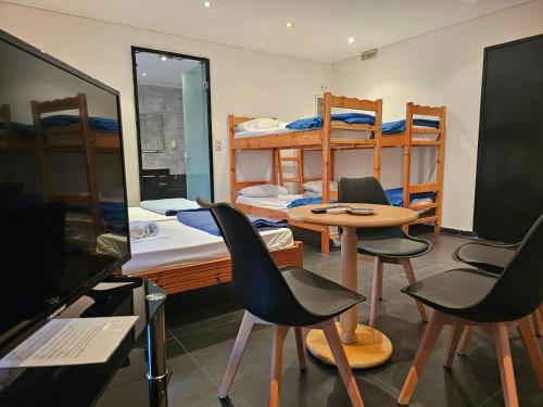 Zimmer mit Etagenbetten sowie einem Tisch und Stühlen in der Unterkunft Feevos in Piräus