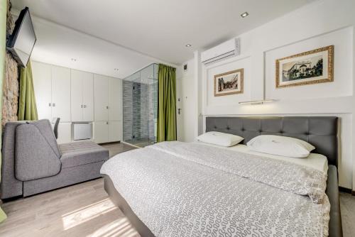 1 dormitorio con 1 cama grande y 1 silla en Luxury rooms Ana in the heart of Split, en Split