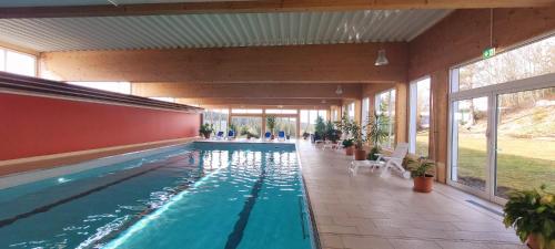 a large swimming pool in a house with windows at Maria Altreichenau in Neureichenau