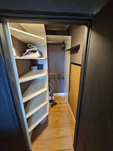 a closet with white shelves and a wooden floor at CENTRAL APARTMAN 7 in Komárno